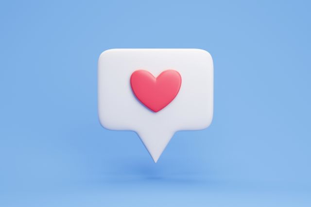 水色の背景の前にある赤いハートが書かれた吹き出し