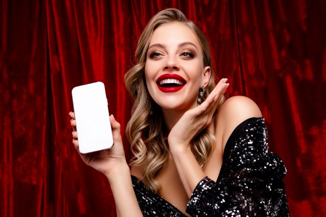 携帯を持って喜ぶ女性